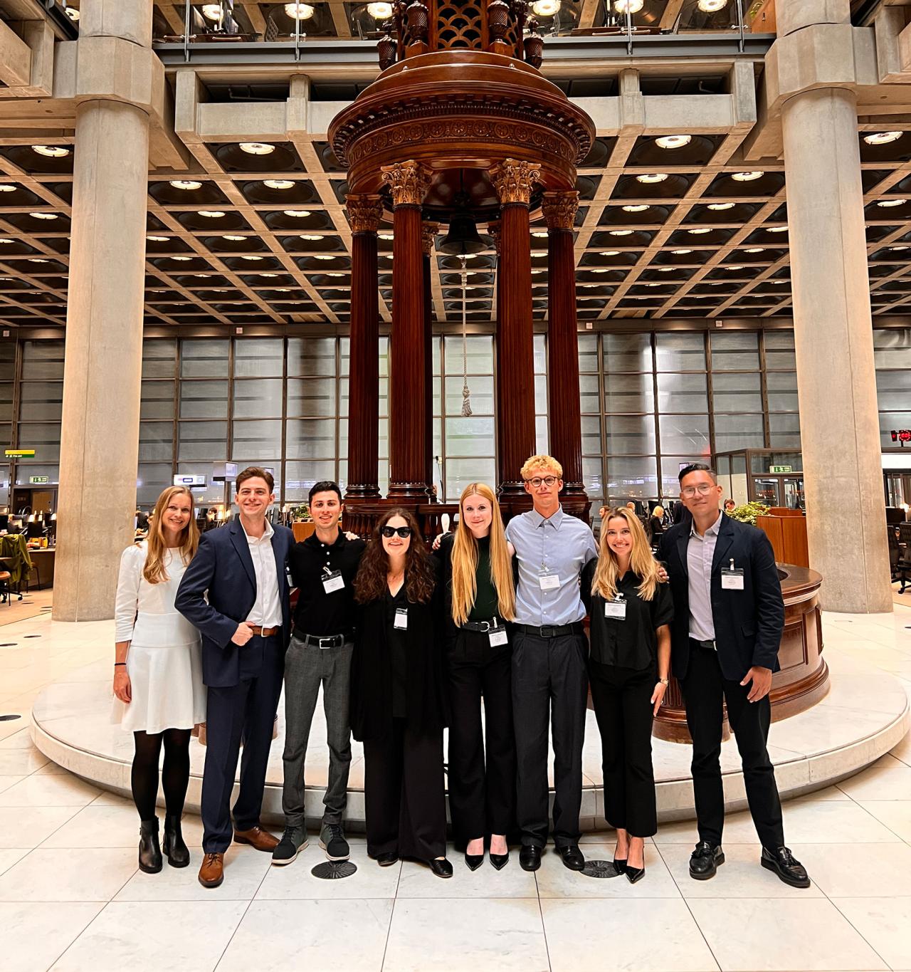 A group of people in formal attire standing at Lloyd's, London