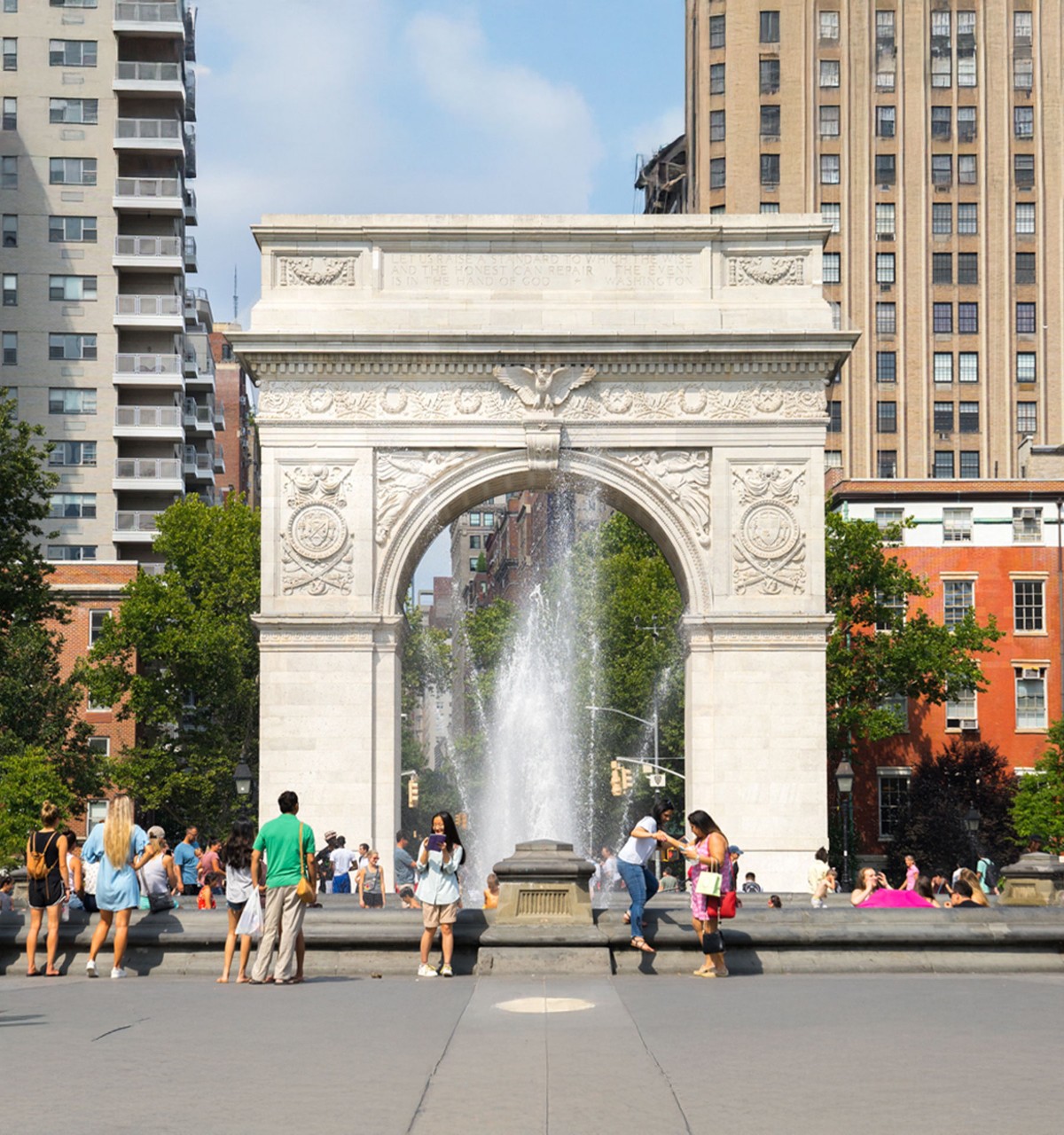 People enjoy a summer day in Washington Square Park in New York City.