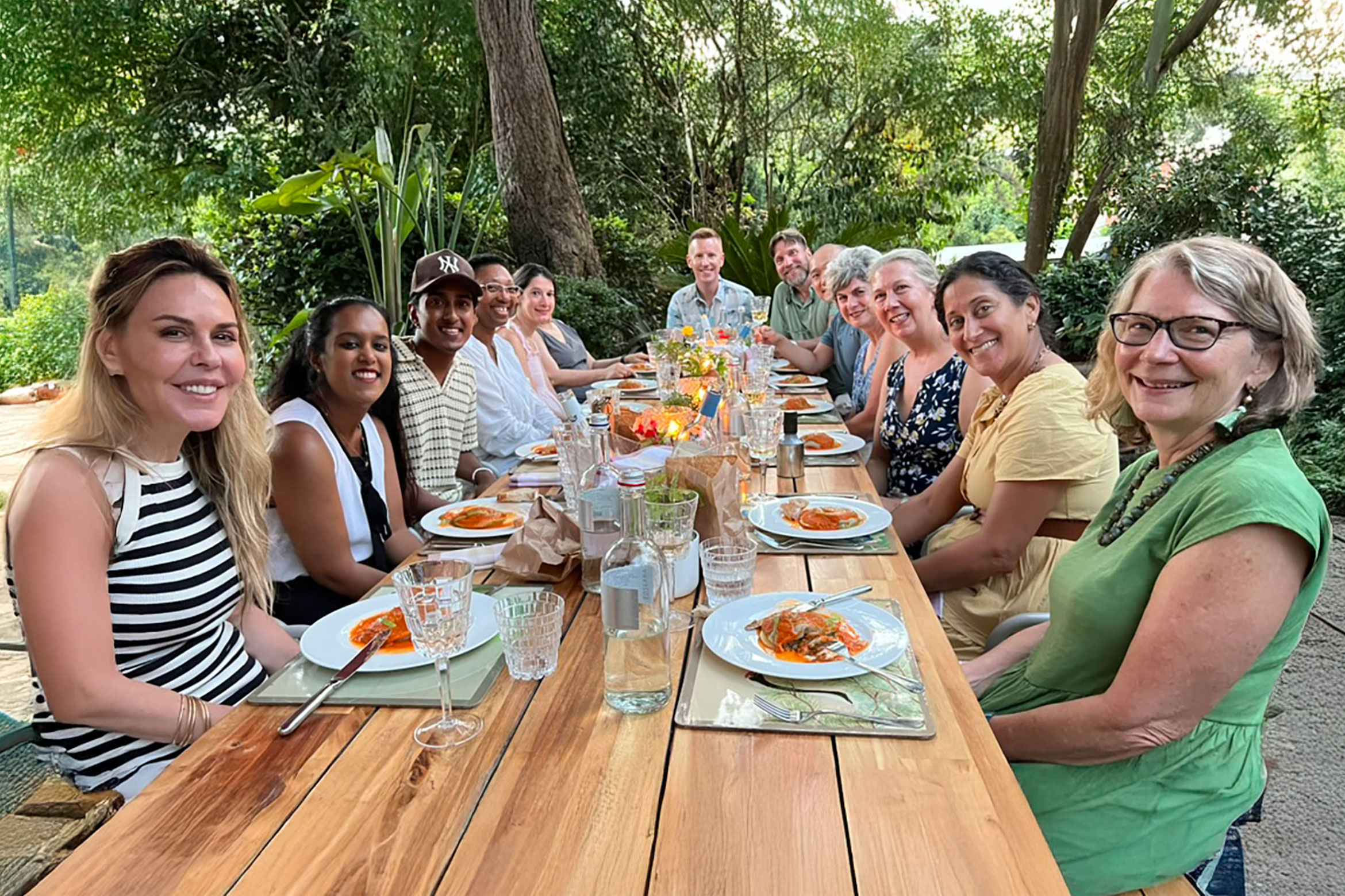 A group of NYU SPS alumni smile for a photo at a dinner table the Inaugural Alumni Travel Program in Florence