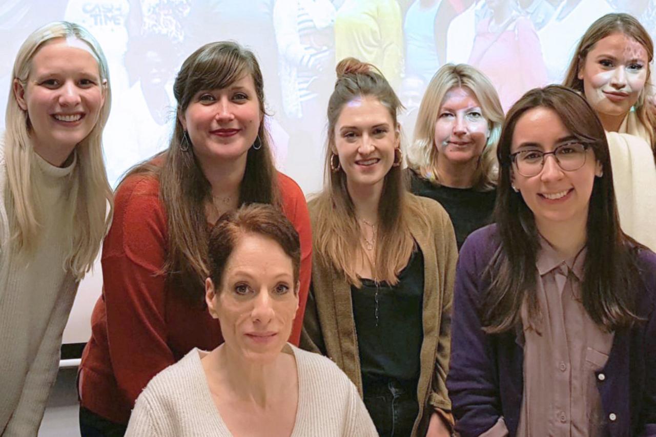 A group of NYU SPS students and faculty pose for a photo during an Institute for Healing of Memories event.