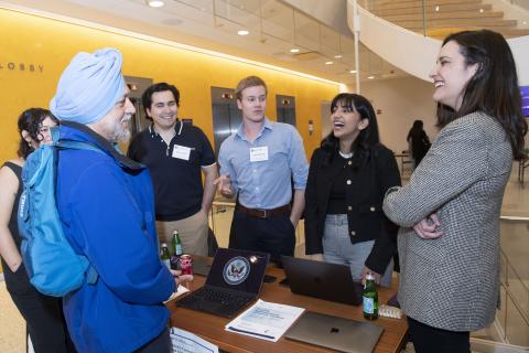 Six people stand around a table and discuss Navigating Synthetic Content at NYU SPS's Center for Global Affairs.