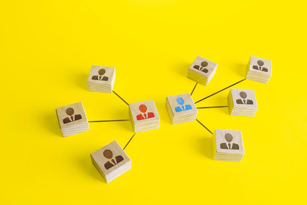 Wooden blocks representing team leaders connected across a yellow background.