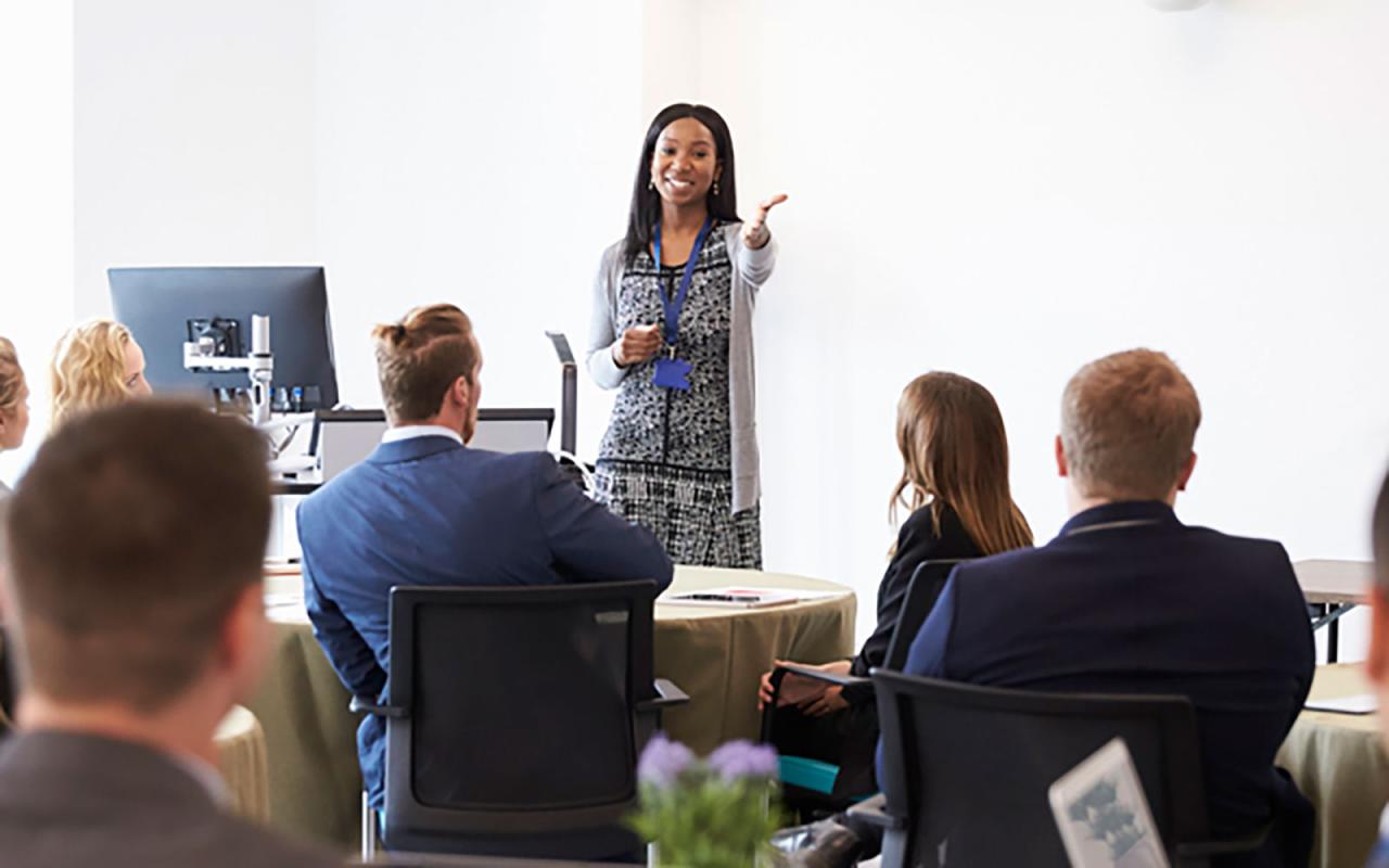 Woman in teaching in front of adult class