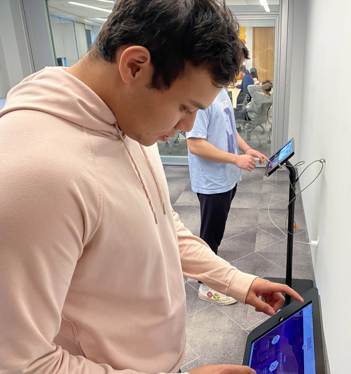 Two students in the HI Hub Learning Lab on tablets.