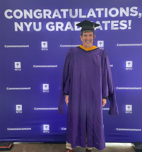 David E. Cooley poses in his graduation cap and gown.
