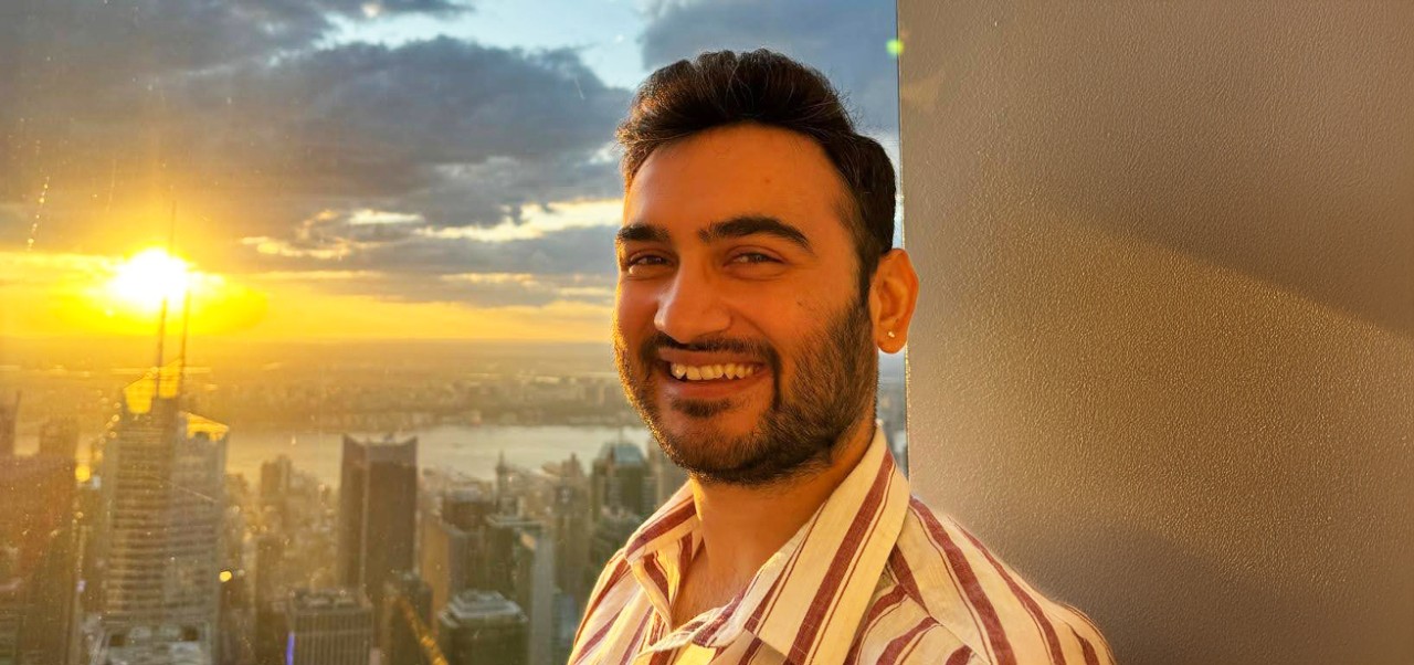 Division of Programs in Business at NYU SPS alumnus Prithviraj Rathore smiles for the camera during sunset in front of the Manhattan skyline.