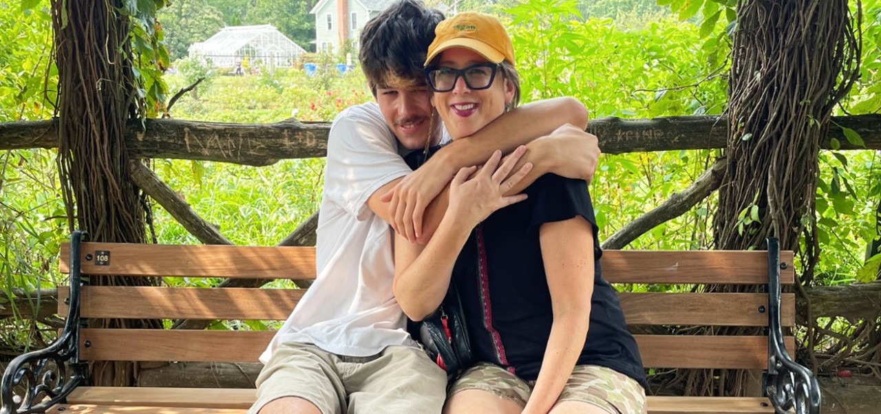 Julie Torres Moskovitz sits on a wooden bench with her son in Elizabeth Park in Hartford on a road trip to Maine.