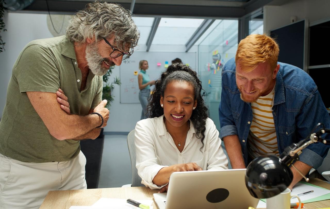 Career compass, three colleagues around a laptop