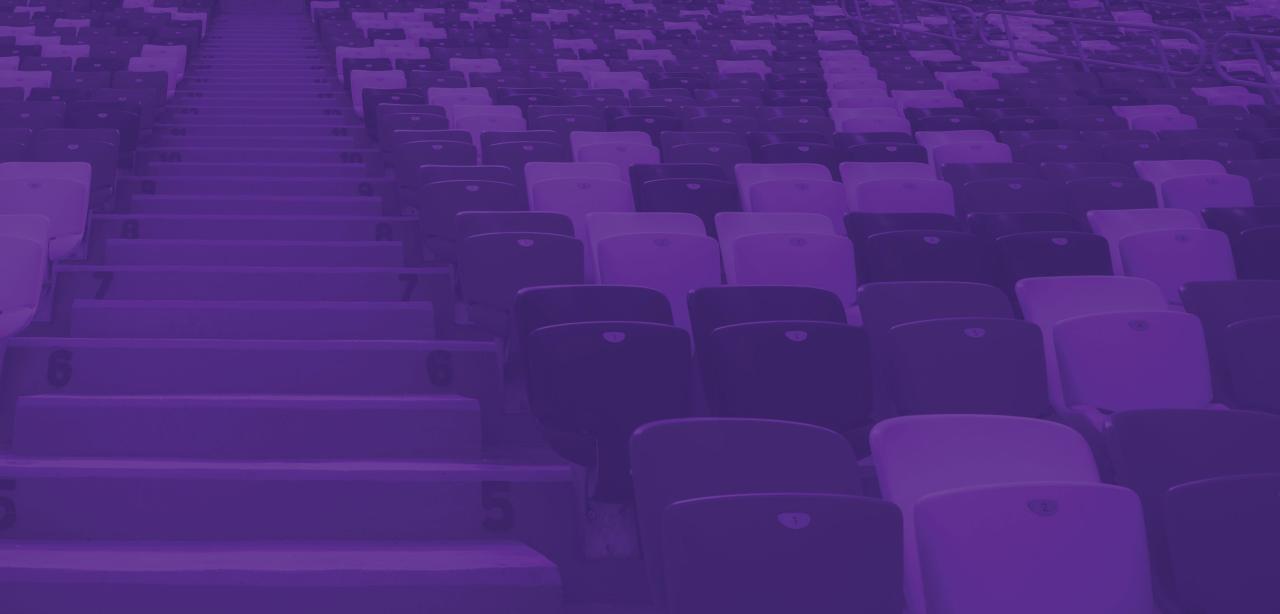 The silhouettes of two men and a woman viewing a major sporting event from a private box.