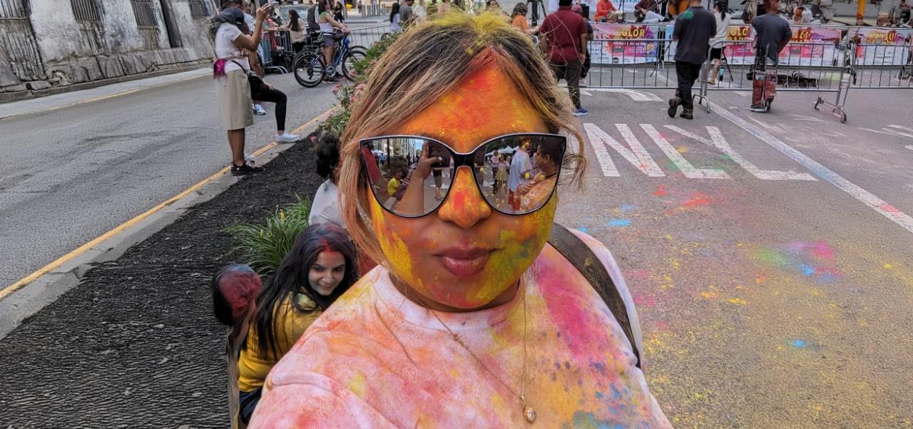 Bhavana Singh, Division of Programs in Business at NYU SPS alumnus, poses for a close-up photo in sunglasses while covered in body paint at a celebration.