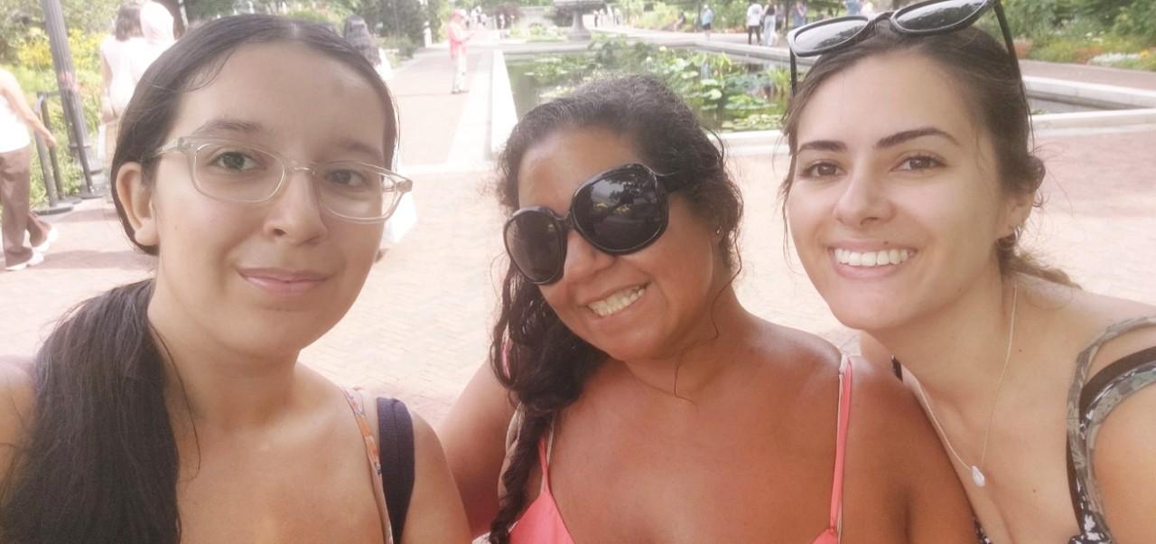 Samantha O'Connell, Center for Publishing and Applied Liberal Arts at NYU SPS alumnus, smiles for the camera with two girlfriends at a botanical garden.