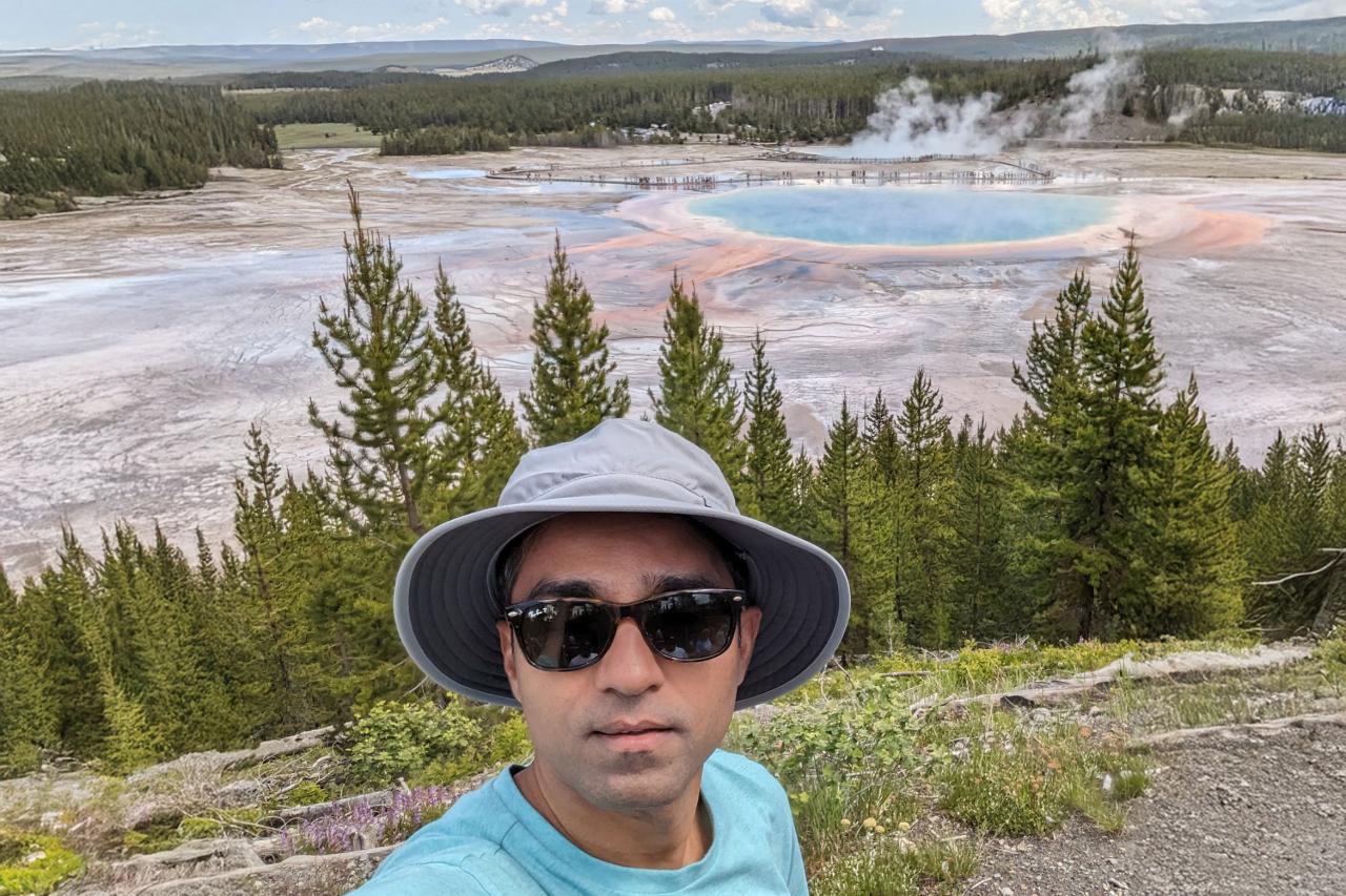 NYU SPS CE faculty member Amar Vajjhala snaps a selfie in front of a geyser at a national park