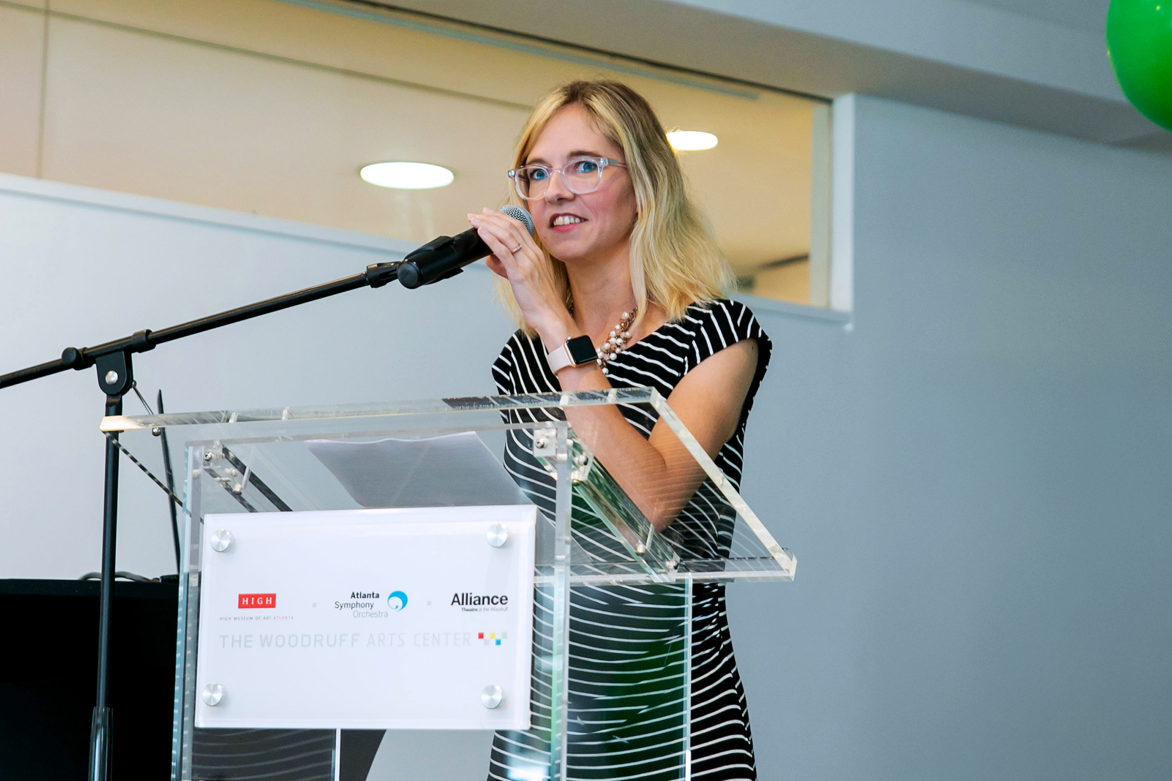 NYU SPS faculty member Kathleen Murphy speaks on a microphone at an event in the Woodruff Arts Center