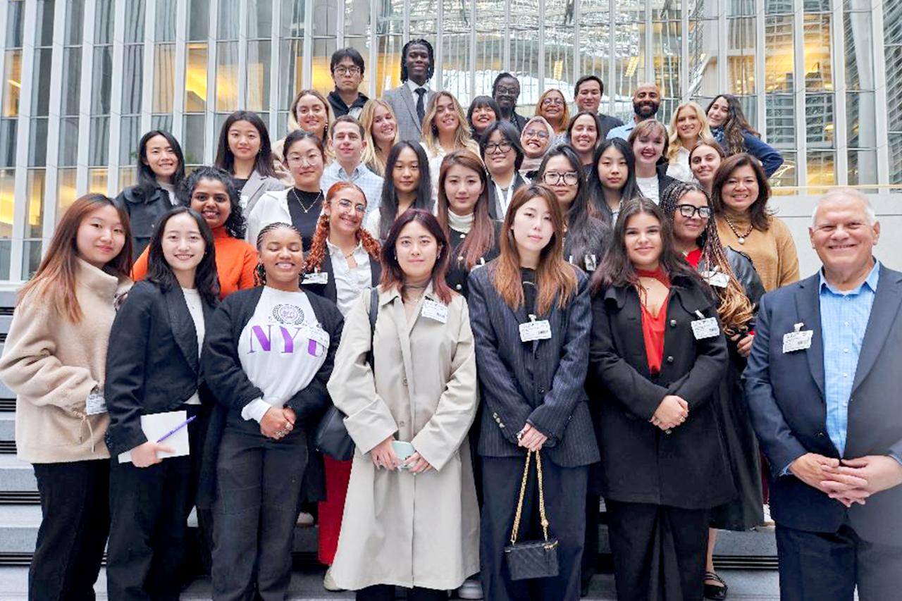 NYU SPS Continuing Education instructor Ronald Naples smiles for a photo on the steps outside the World Bank with a large group of students