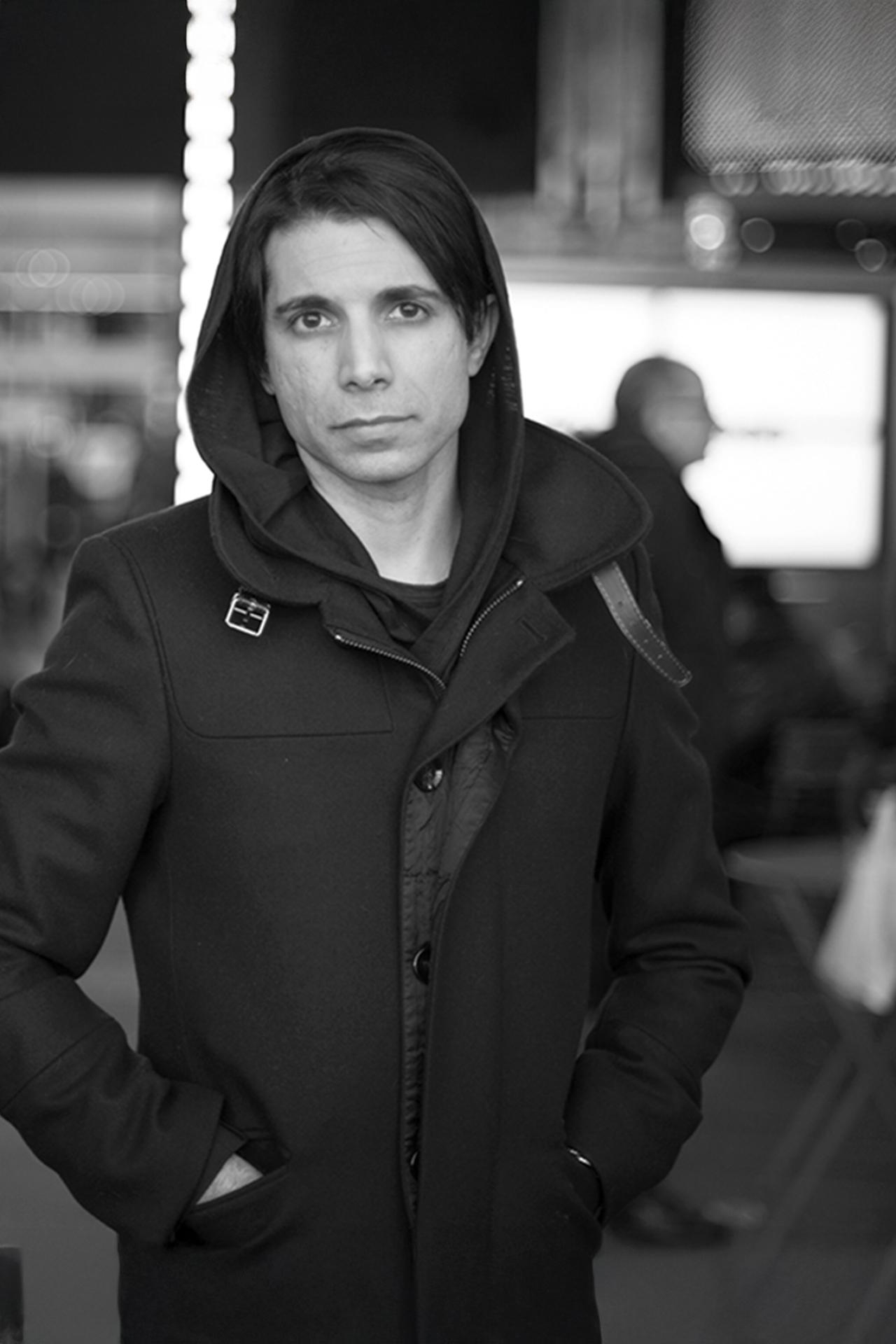 Black and white photo of NYU SPS CE instructor Simon TaufiQue wearing a dark jacket with the hood up