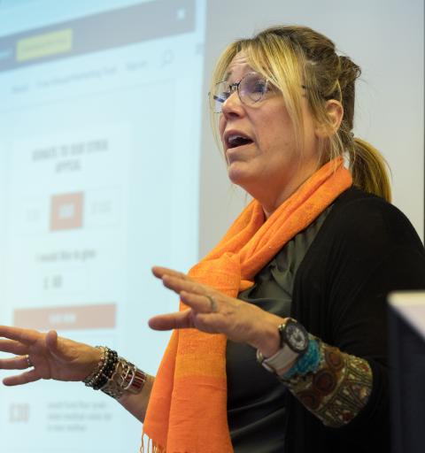 Woman standing in front of projector screen talking