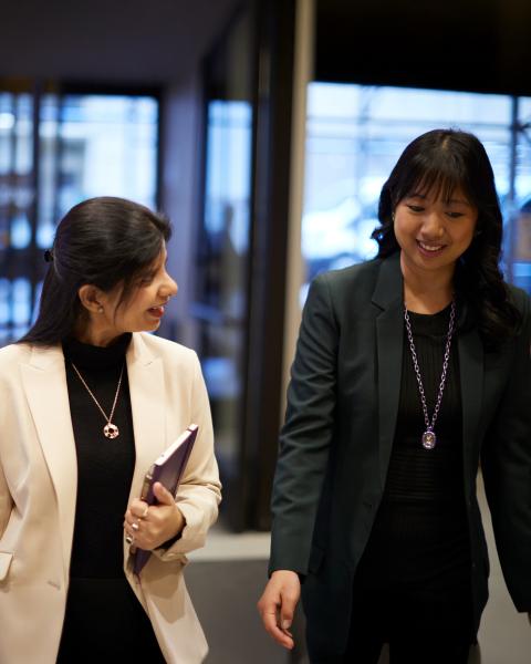 An NYU SPS graduate student walks down a hallway with her admissions counselor while discussing tuition and financial aid