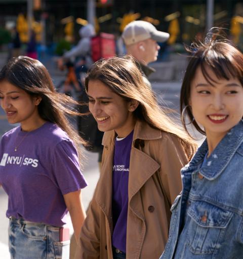 3 students walking and smiling