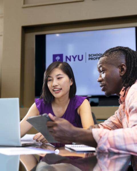 A prospective NYU SPS student sits at a table with an undergraduate admissions counselor to discuss tuition and financial aid